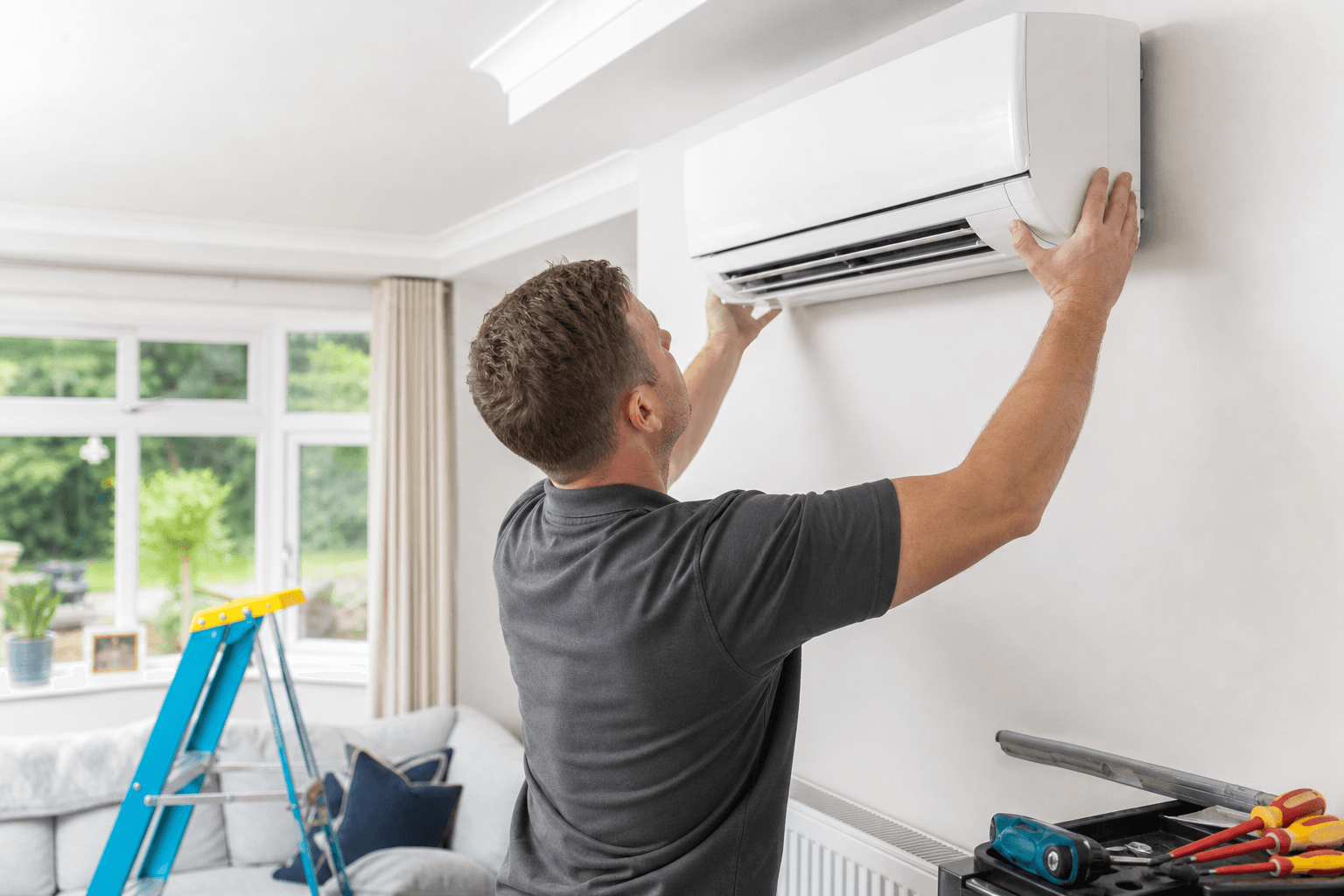 Engineer installing a wall-mounted air conditioning unit